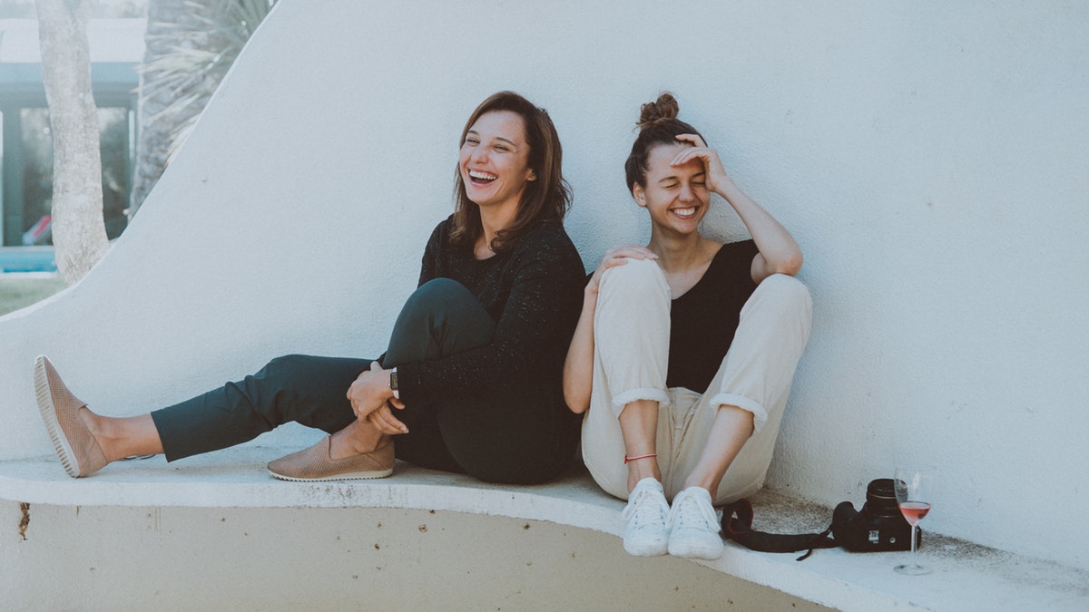  two women sitting on a white bench at benzodiazepine addiction rehab center