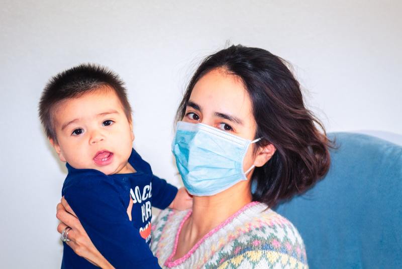 a mum wearing a face mask with her child